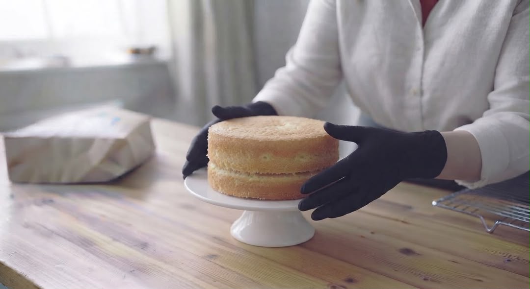 Stacking fresh sponge layers on a cake stand
